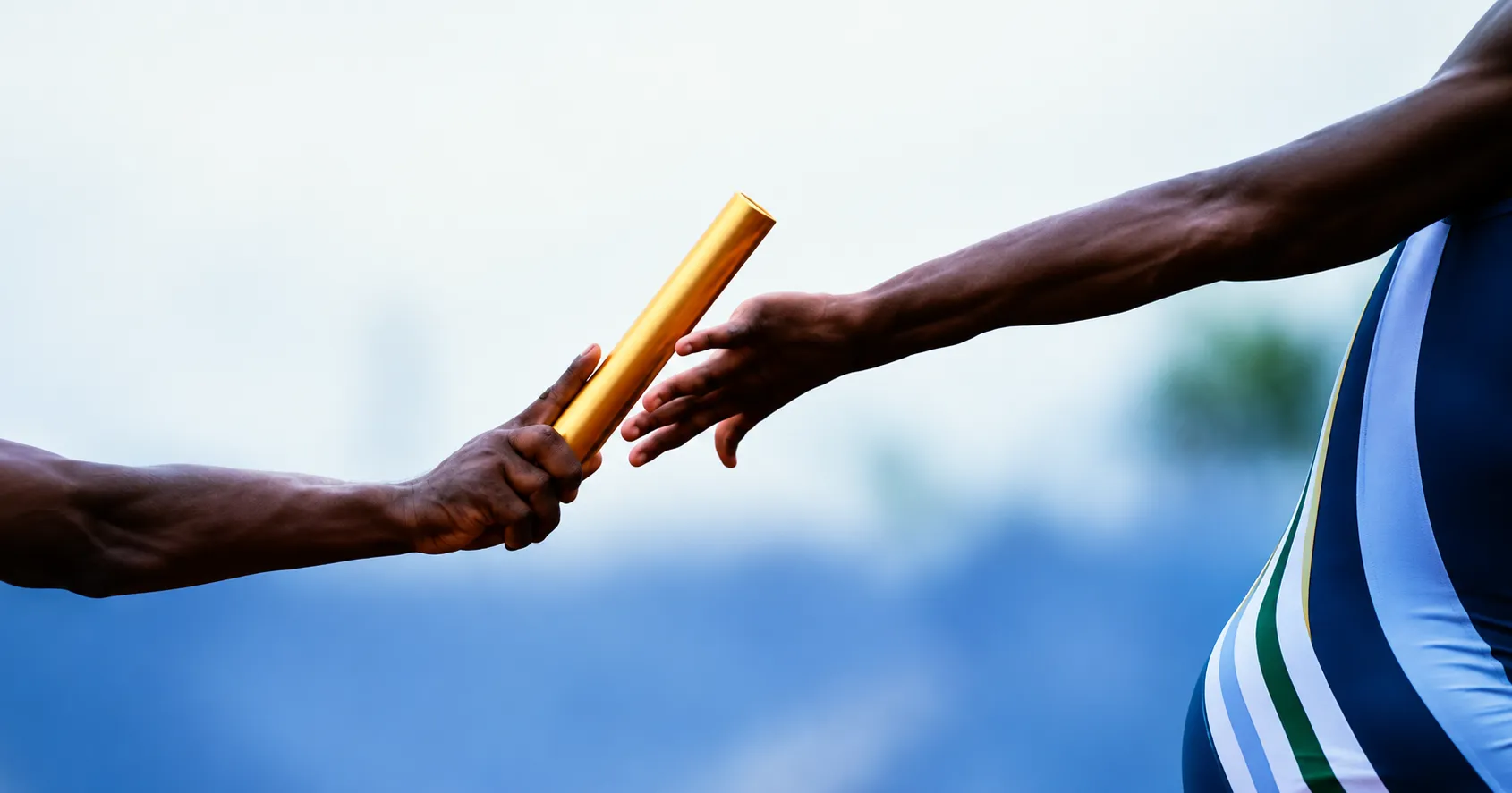 One relay runner passing a golden baton into the hand of the next